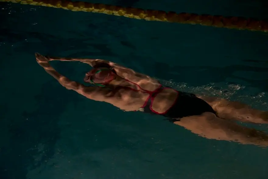 A swimmer practising backstroke in a lane